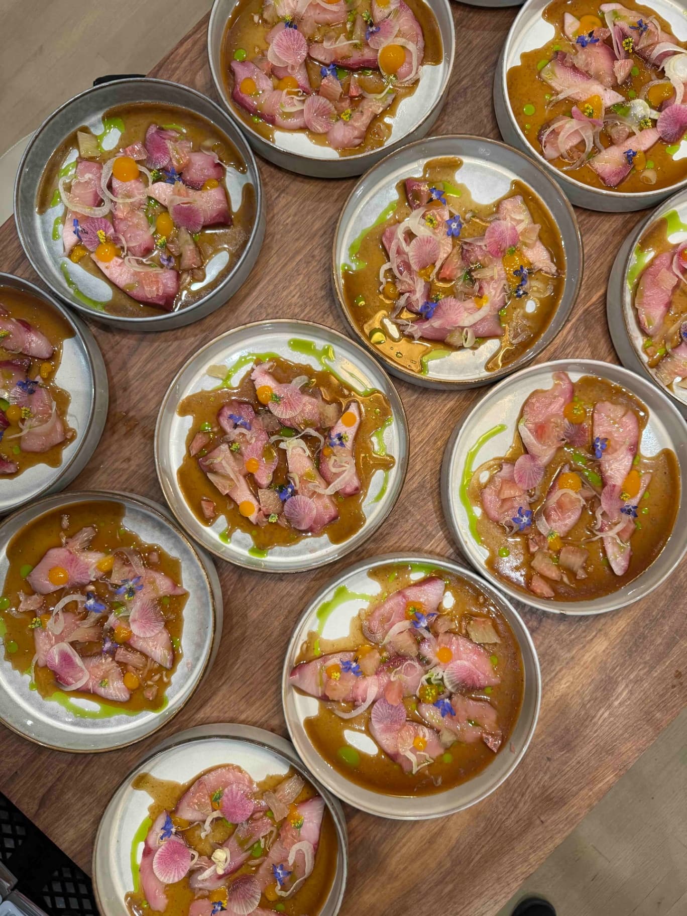 Hamachi crudo plates lined up at a Luma Society dinner